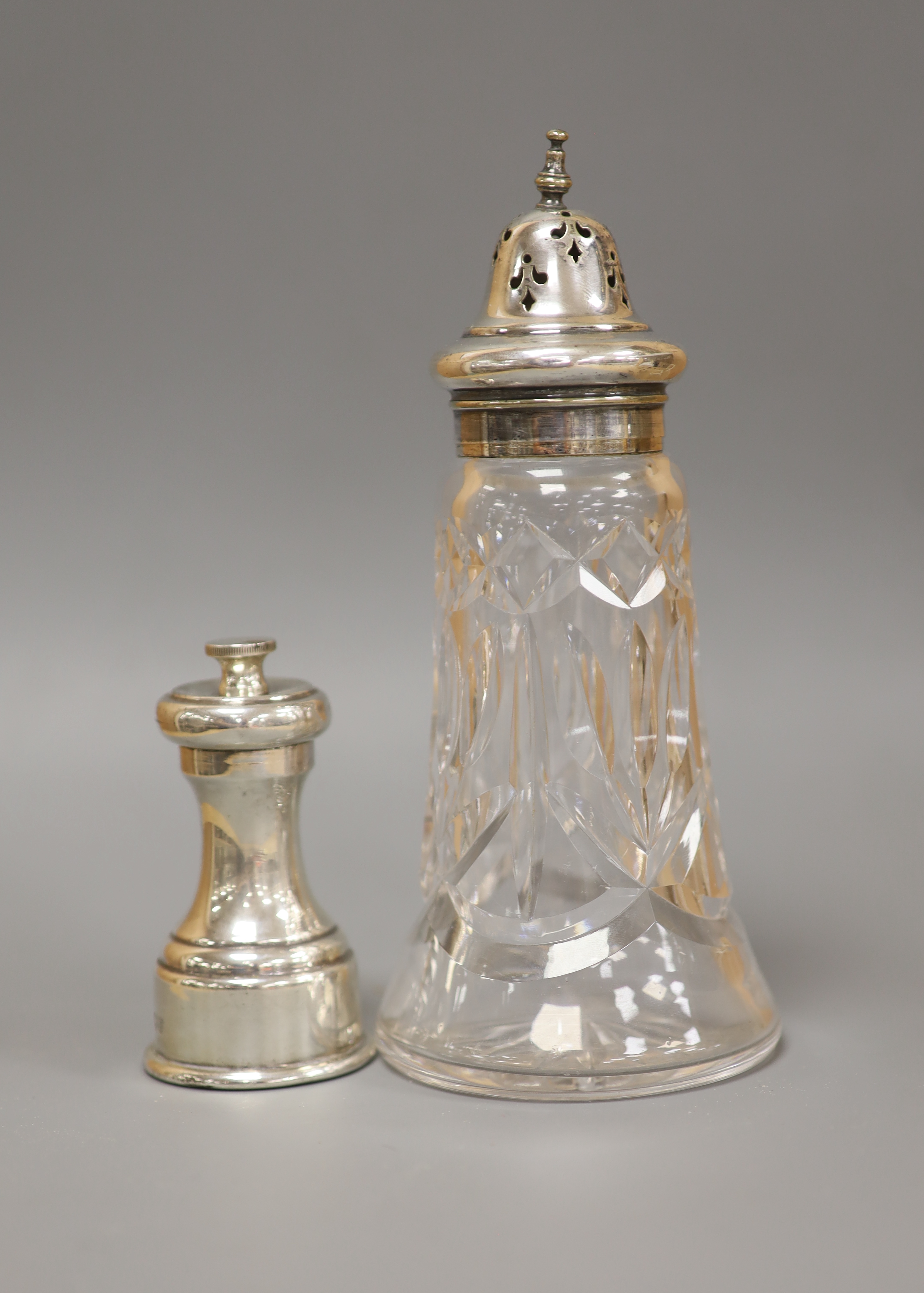 A modern silver pepper mill, Mappin & Web, Sheffield, 1957, 85mm and silver plated mounted glass sugar sifter.